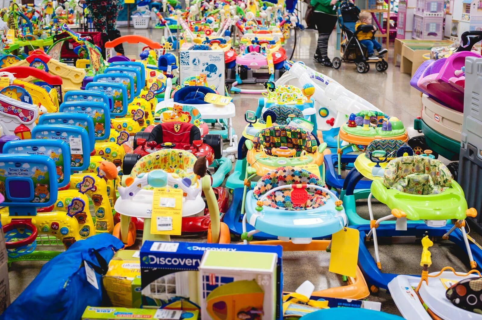 Rows and rows of toys and baby gear at a sale. 